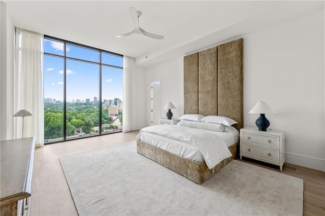 2425 Peachtree Rd NE Unit 1503, Atlanta, GA 30305 - bedroom with expansive windows, multiple windows, wood finished floors, a view of skyline, and a ceiling fan