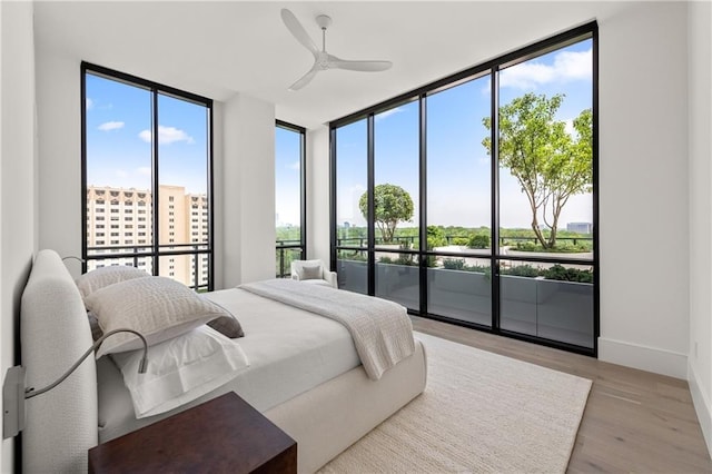 2425 Peachtree Rd NE Unit 1503, Atlanta, GA 30305 - bedroom with light wood-style flooring, access to outside, a wall of windows, baseboards, and ceiling fan