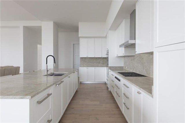 2425 Peachtree Rd NE Unit 1503, Atlanta, GA 30305 - kitchen featuring a sink, wall chimney exhaust hood, decorative backsplash, a large island, and white cabinets