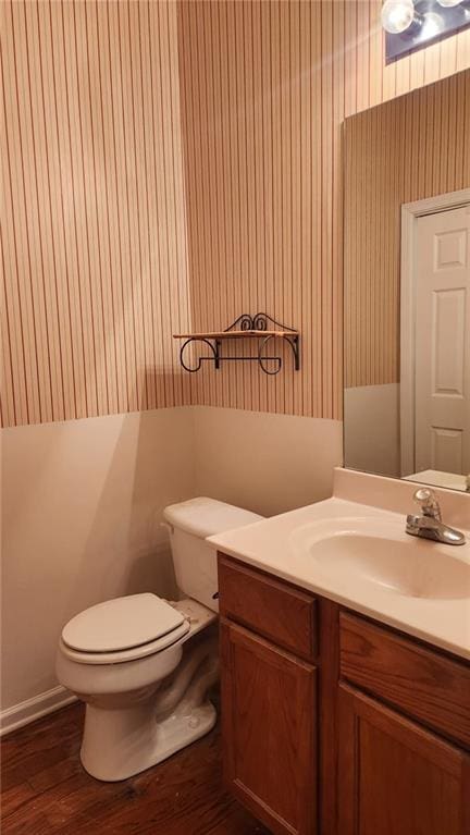 bathroom with vanity, toilet, and wood-type flooring