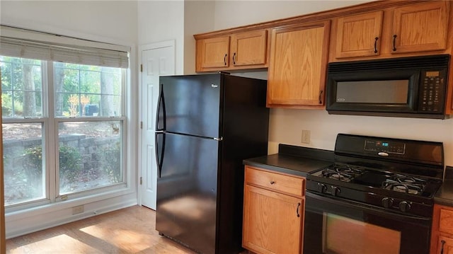 kitchen featuring black appliances and light hardwood / wood-style flooring