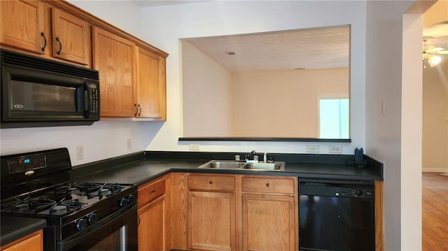 kitchen with black appliances, sink, and hardwood / wood-style floors