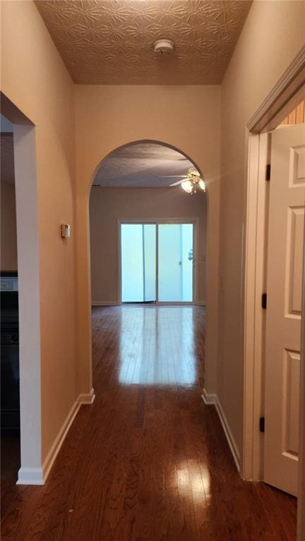 hallway featuring a textured ceiling and dark wood-type flooring