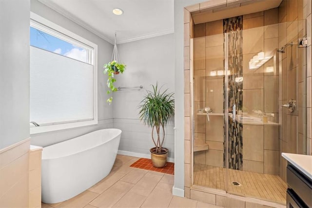 bathroom with a freestanding tub, vanity, ornamental molding, tile patterned floors, and a stall shower