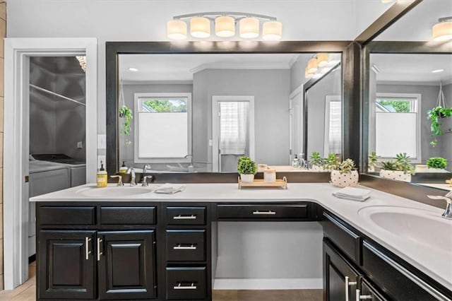 bathroom featuring double vanity, a healthy amount of sunlight, a sink, and washer and dryer