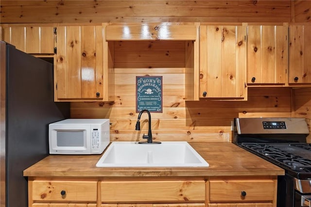251 Honeysuckle Way, Blue Ridge, GA 30513 - kitchen with stainless steel gas range, wooden counters, white microwave, a sink, and wood walls