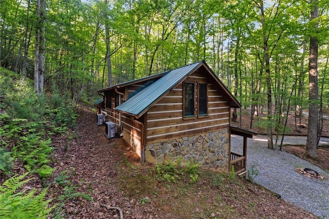 251 Honeysuckle Way, Blue Ridge, GA 30513 - view of side of home with stone siding, metal roof, central air condition unit, and a forest view