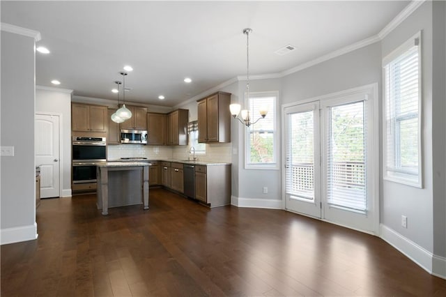 kitchen featuring decorative light fixtures, a center island, stainless steel appliances, and dark hardwood / wood-style flooring