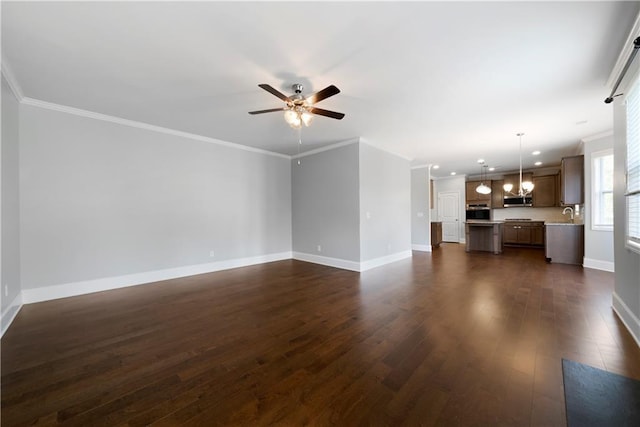 unfurnished living room with ornamental molding, ceiling fan, dark wood-type flooring, and sink