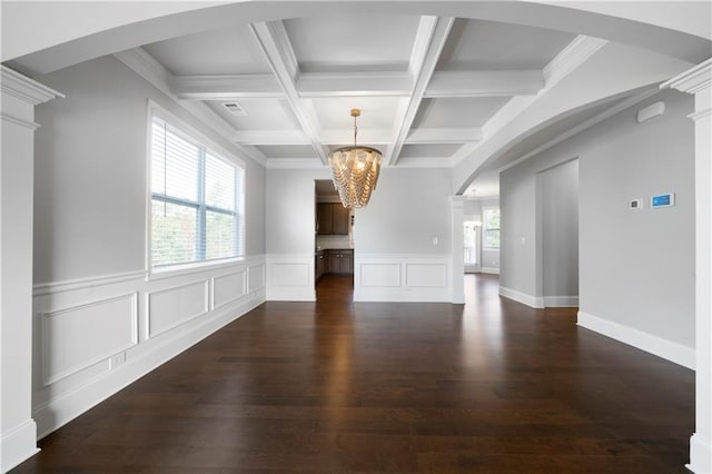 unfurnished living room with a chandelier, beam ceiling, dark wood-type flooring, and coffered ceiling