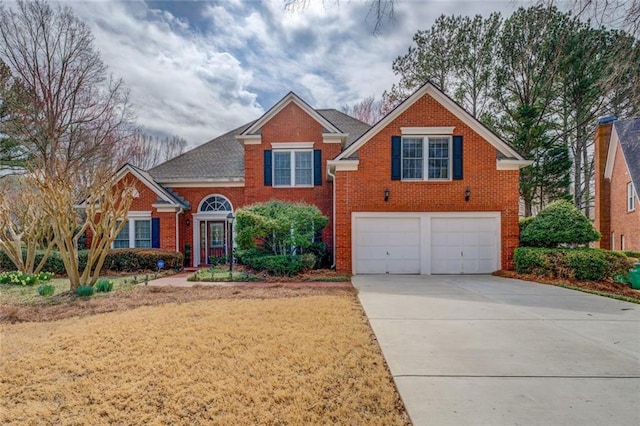 traditional-style home featuring brick siding, driveway, and an attached garage