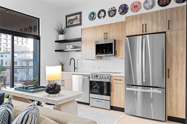 567 Ponce De Leon Ave NE Unit 606, Atlanta, GA 30308 - kitchen featuring stainless steel appliances, open shelves, light countertops, tasteful backsplash, and a sink