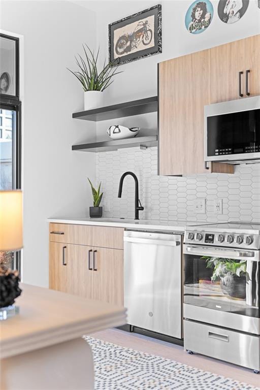 567 Ponce De Leon Ave NE Unit 606, Atlanta, GA 30308 - kitchen featuring stainless steel appliances, light brown cabinetry, light countertops, tasteful backsplash, and modern cabinets