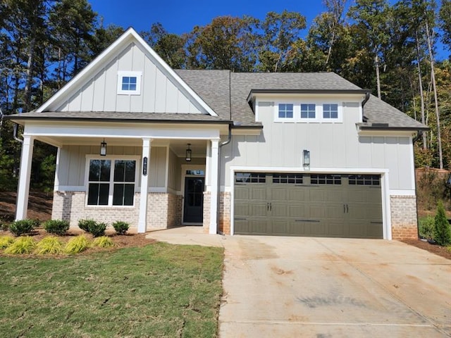 view of front of house featuring concrete driveway, brick siding, board and batten siding, and an attached garage