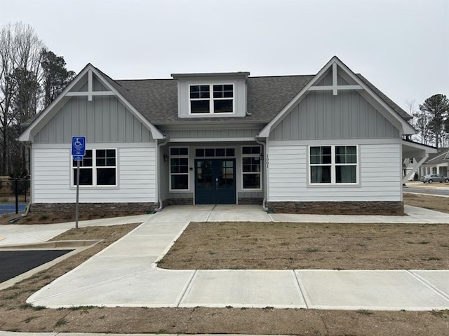 view of front of house featuring a shingled roof, board and batten siding, and french doors