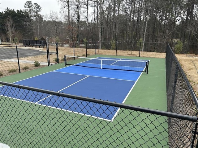 view of tennis court featuring fence