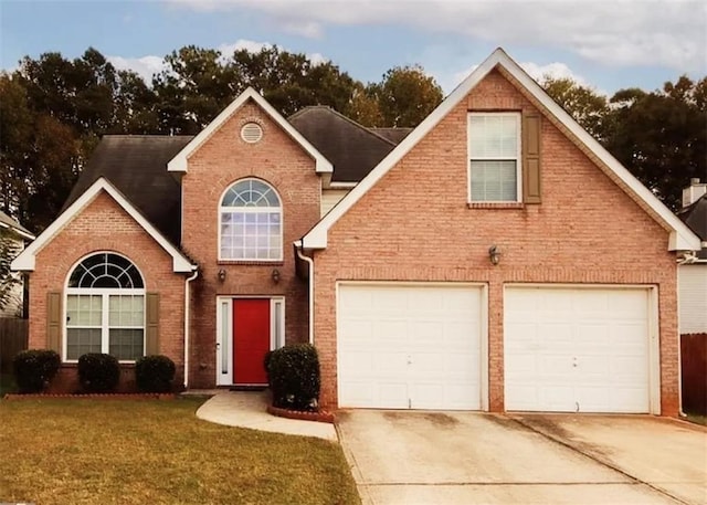 traditional-style home with a garage, brick siding, concrete driveway, and a front yard