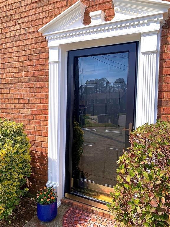 entrance to property featuring brick siding