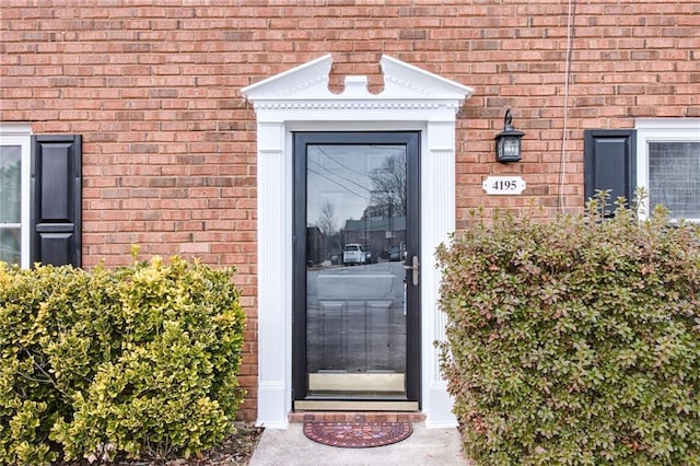 entrance to property featuring brick siding