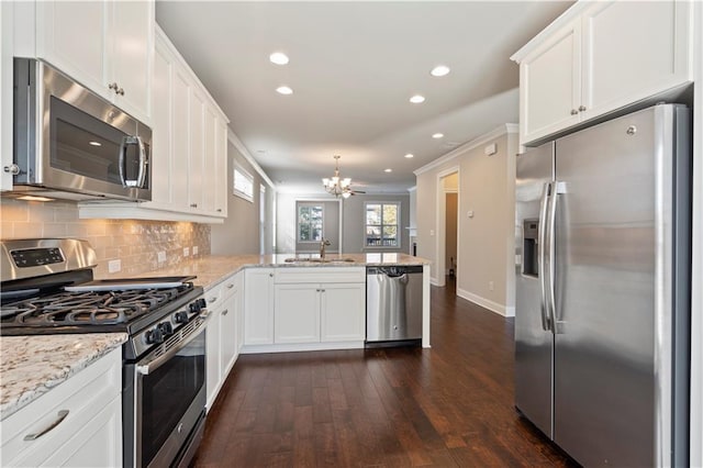 kitchen featuring white cabinetry, sink, stainless steel appliances, dark wood-type flooring, and kitchen peninsula