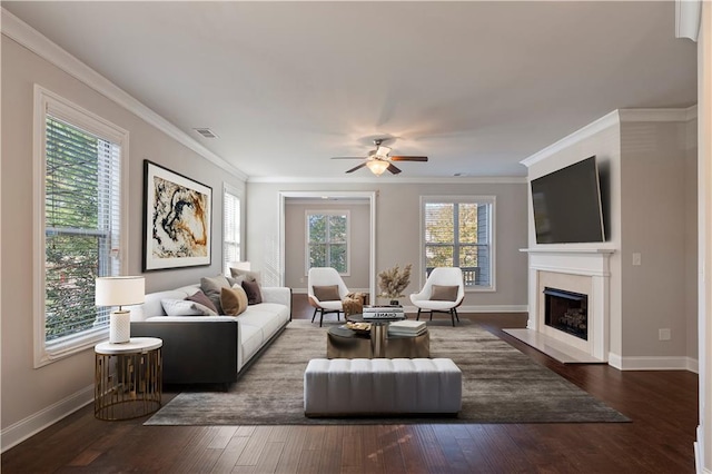 living room featuring a healthy amount of sunlight, dark hardwood / wood-style flooring, and crown molding