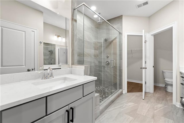 bathroom featuring toilet, an enclosed shower, and vanity