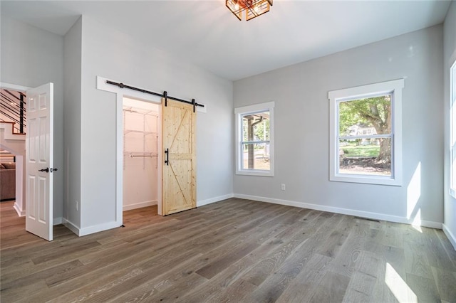 unfurnished bedroom featuring light hardwood / wood-style flooring, a closet, and a barn door