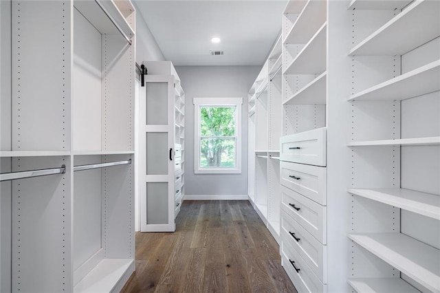 spacious closet featuring dark hardwood / wood-style flooring