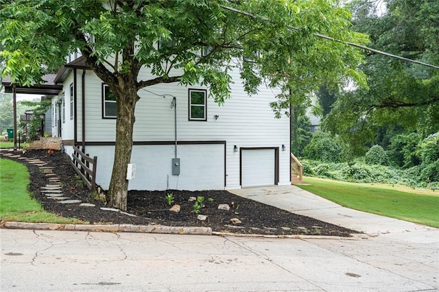 view of property exterior with a garage and a lawn