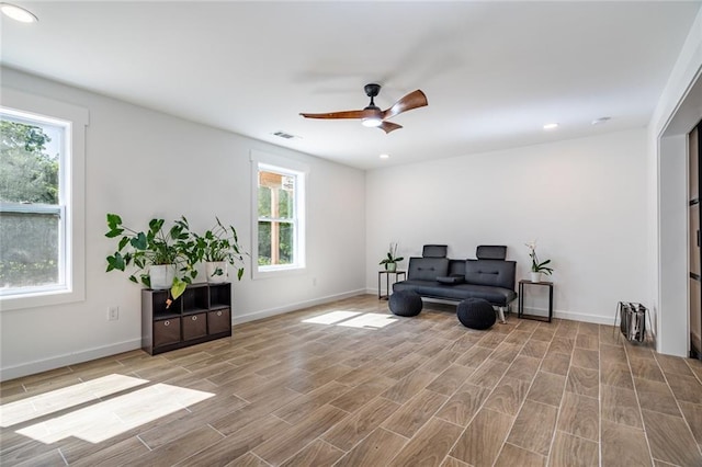 living area with ceiling fan and a healthy amount of sunlight