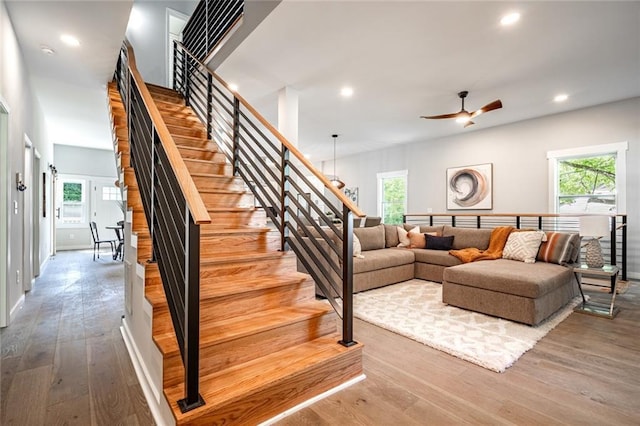 stairs with ceiling fan, hardwood / wood-style floors, and a wealth of natural light