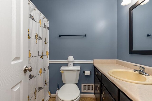 full bath with visible vents, a shower with shower curtain, toilet, and vanity