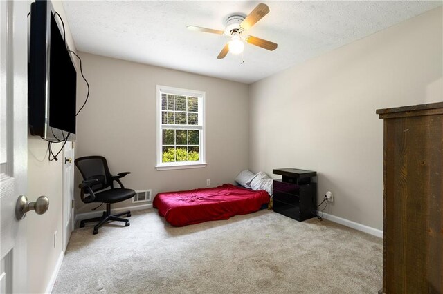 carpeted bedroom with visible vents, a ceiling fan, and baseboards
