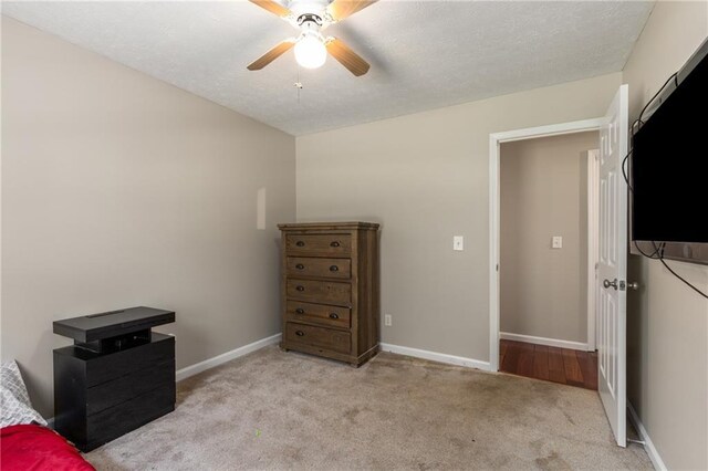 bedroom featuring baseboards, a ceiling fan, and light colored carpet