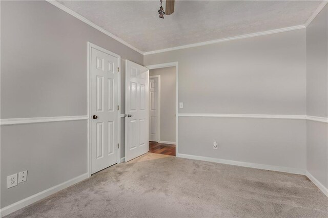 unfurnished bedroom featuring crown molding, baseboards, ceiling fan, a textured ceiling, and carpet flooring
