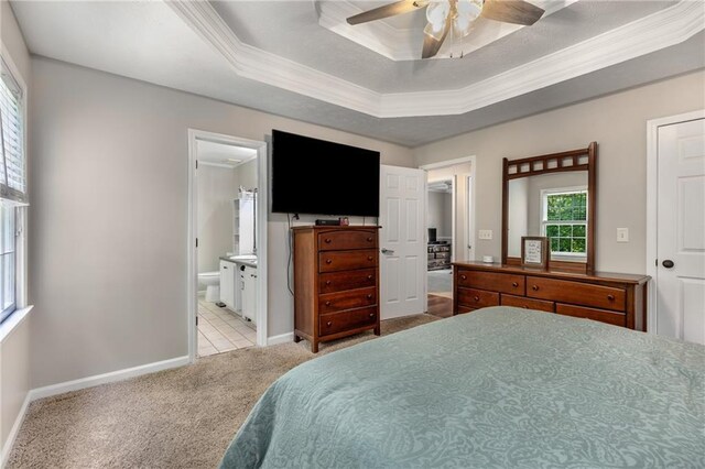 bedroom with a ceiling fan, crown molding, a raised ceiling, baseboards, and carpet flooring
