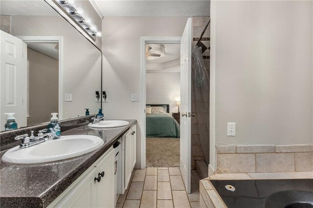 ensuite bathroom featuring double vanity, a sink, connected bathroom, and a textured ceiling