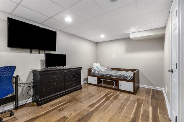 bedroom with recessed lighting, baseboards, a drop ceiling, and wood finished floors