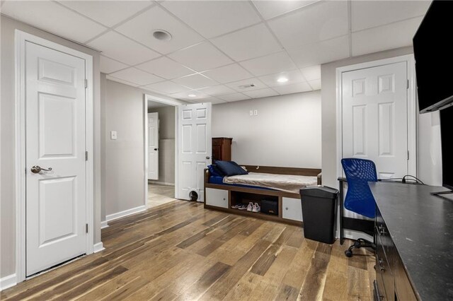 home office with baseboards, a drop ceiling, recessed lighting, and wood finished floors