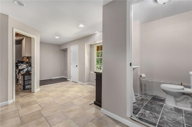 bathroom with baseboards, recessed lighting, and toilet