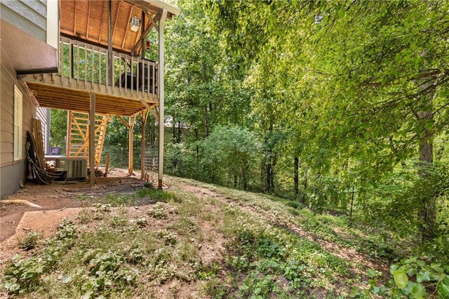 view of yard featuring a wooden deck, stairs, and central AC unit