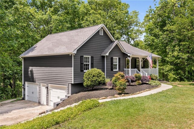 view of home's exterior with covered porch, roof with shingles, a lawn, concrete driveway, and an attached garage