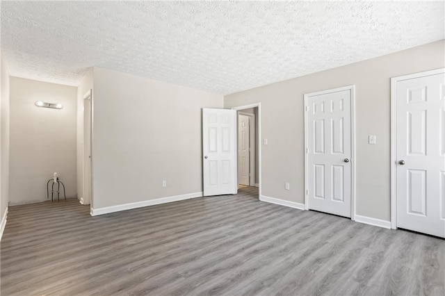 801 Hemingway Rd, Stone Mountain, GA 30088 - unfurnished bedroom featuring baseboards, light wood-style flooring, and a textured ceiling
