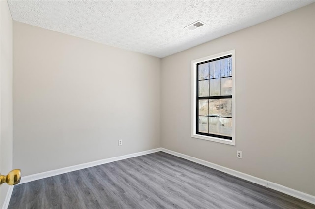 801 Hemingway Rd, Stone Mountain, GA 30088 - unfurnished room featuring a textured ceiling, dark wood finished floors, visible vents, and baseboards