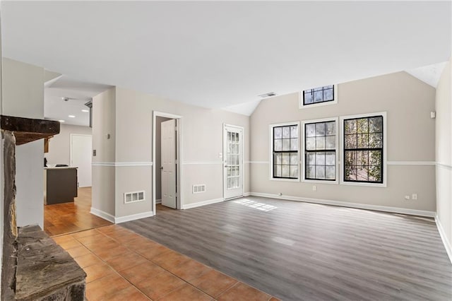 801 Hemingway Rd, Stone Mountain, GA 30088 - unfurnished living room featuring visible vents, vaulted ceiling, baseboards, and wood finished floors