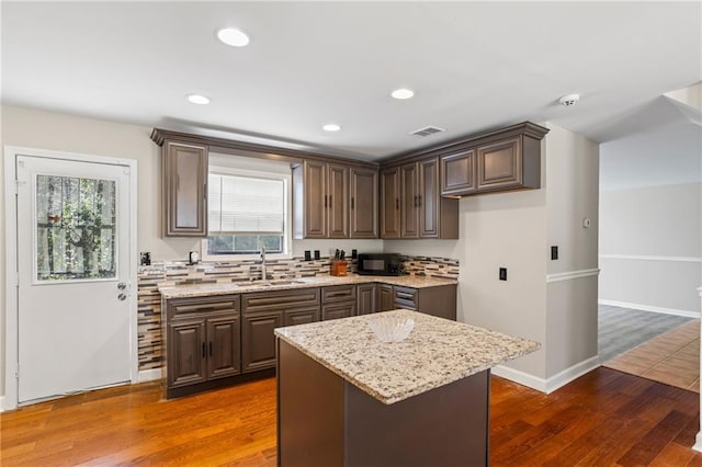 801 Hemingway Rd, Stone Mountain, GA 30088 - kitchen featuring a sink, light stone counters, a kitchen island, and dark wood finished floors
