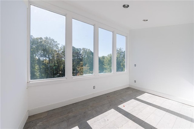 empty room with hardwood / wood-style floors and plenty of natural light