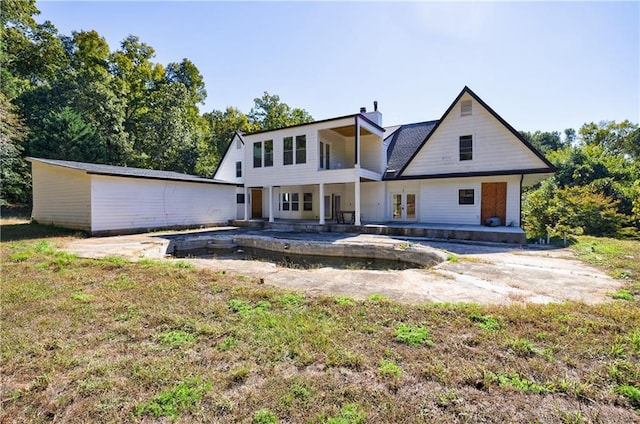 rear view of house with a patio and a lawn