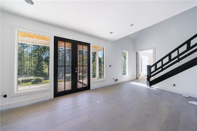 entrance foyer featuring hardwood / wood-style floors, french doors, and vaulted ceiling