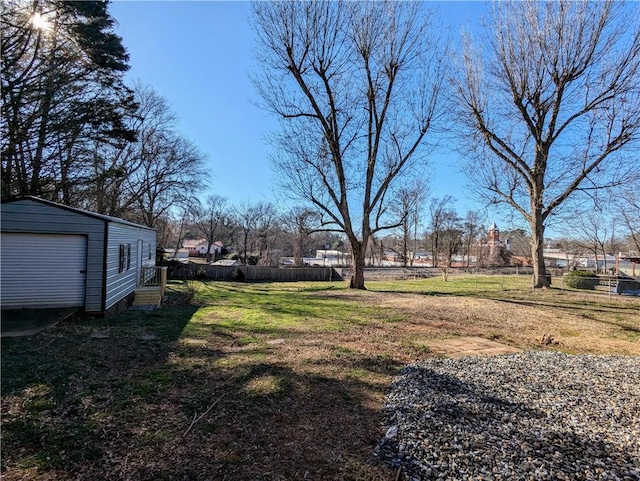 view of yard with fence and an outdoor structure